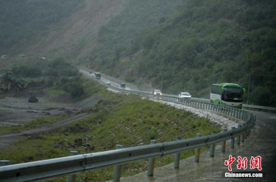 大客车载着游客冒雨撤离。 中新社记者 刘忠俊 摄