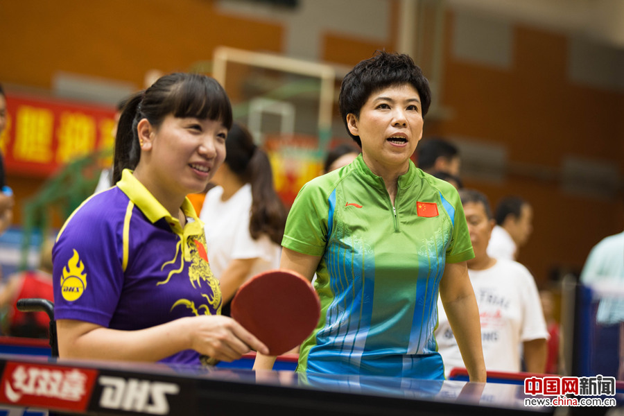 2017年8月10日，第七届残疾人健身周推广日活动在京举行。图为邓亚萍在活动现场指导残疾人女乒选手薛娟打球。