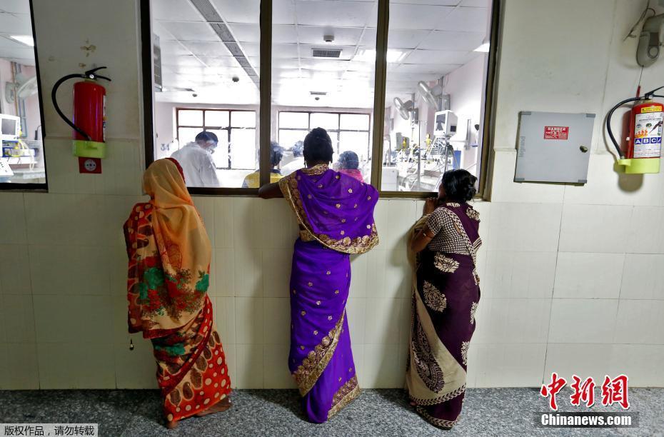 图为几位妇女站在该医院ICU外。