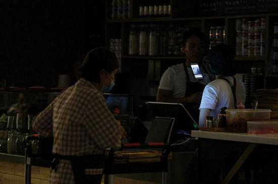 台北101大楼也停电,美食街的民众摸黑用餐。