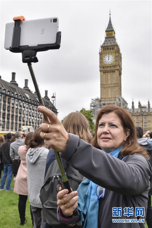 8月21日，在英国伦敦，一名游客在“大本钟”前自拍。