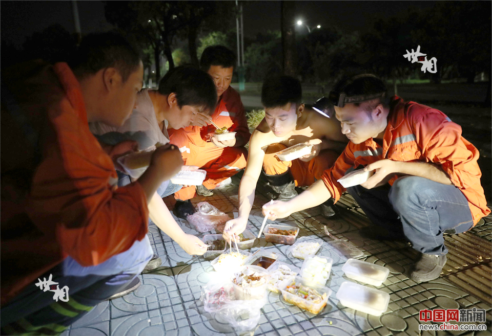 午夜時分，戴帥和工友們在街頭吃盒飯。由於要徹夜施工，為保障力氣，午夜這一餐必不可少。