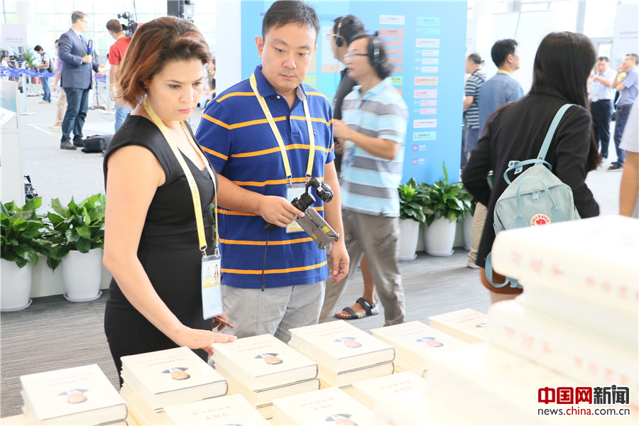 参加此次会议的国内外媒体记者在书展区参观。