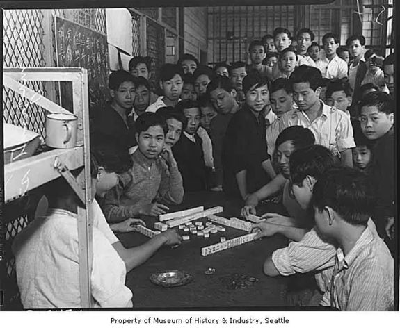 ▲资料图片：1938年，几名年轻人在移民中心打麻将。