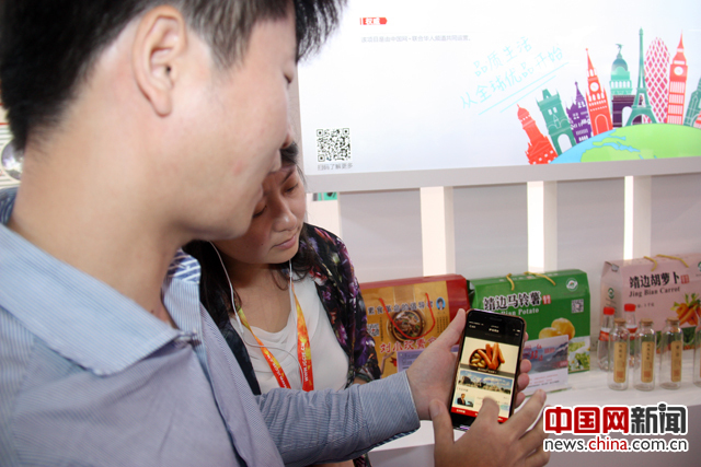 工作人员用手机向观众演示如何扫“华人码”了解一个商品的“前世今生”。 摄影 中国网记者 苏向东
