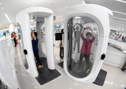 乘客接受全身安检仪检查。（图片来源：韩联社）