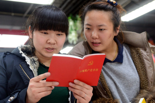 资料图片：2012年11月23日，两名读者在翻阅刚购买的《中国共产党章程》。新华社记者 林宏 摄