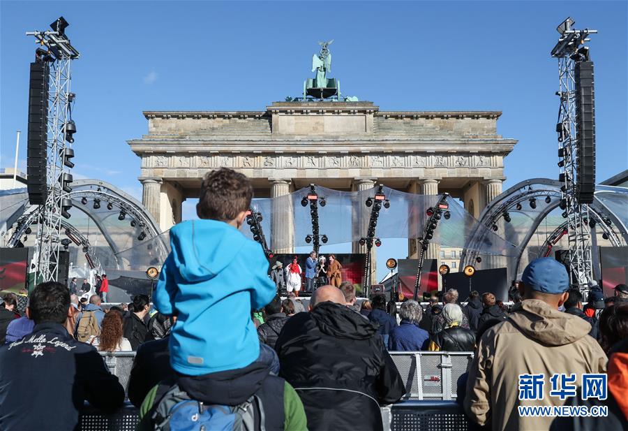 10月3日，人们在德国柏林勃兰登堡门前举行的统一日庆祝活动上观看演出。