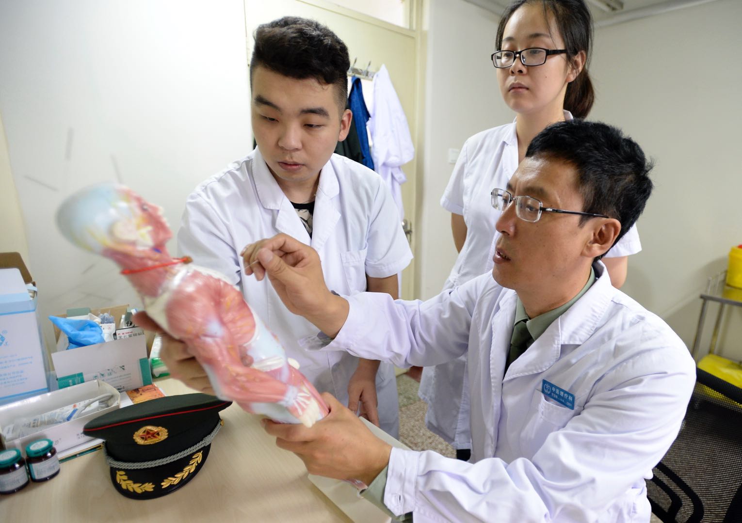 贺登峰（右）在给地方医学院来实习的学生传授针灸技术。