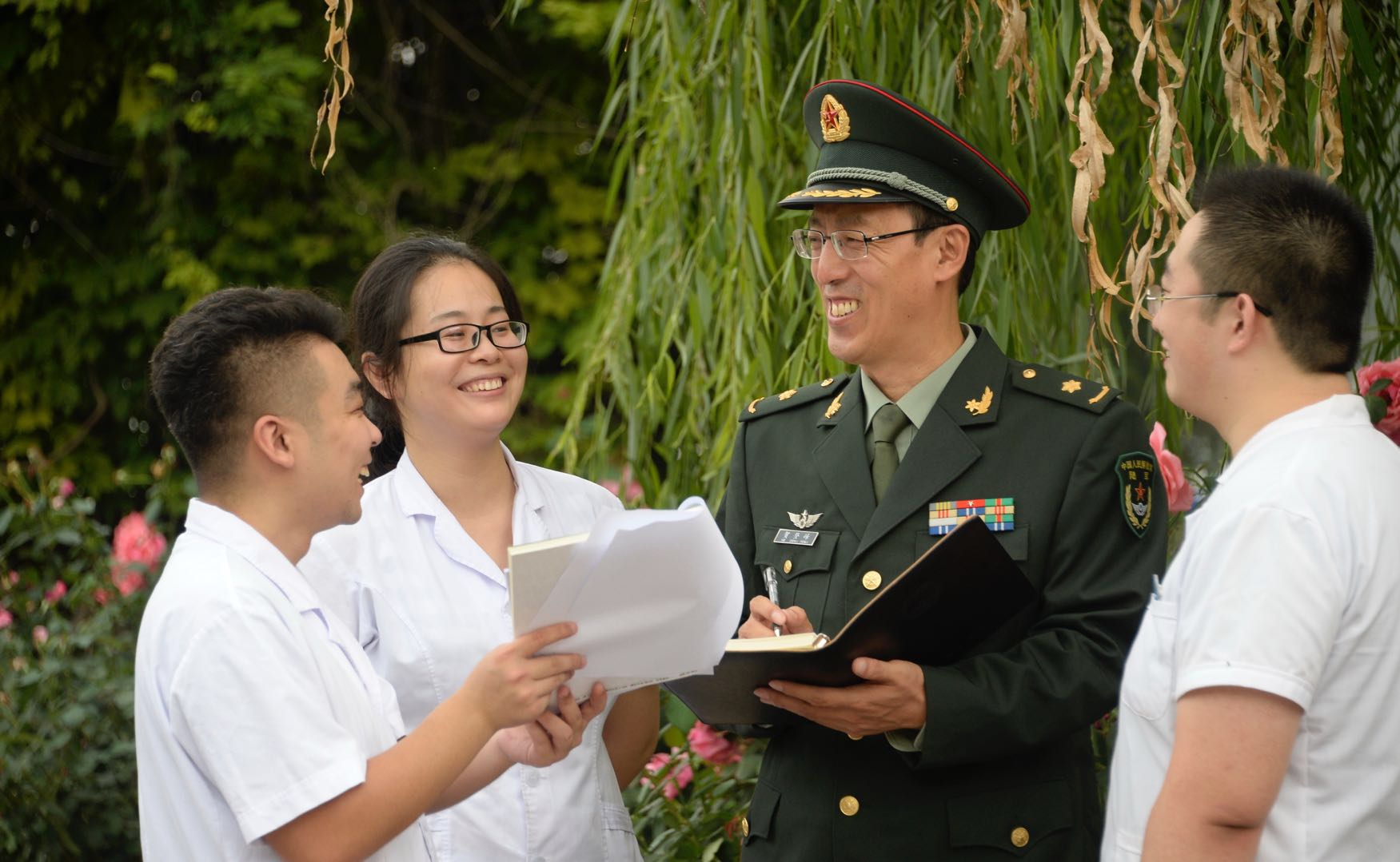 贺登峰（右二）在与在校的中医专业学生们交流。