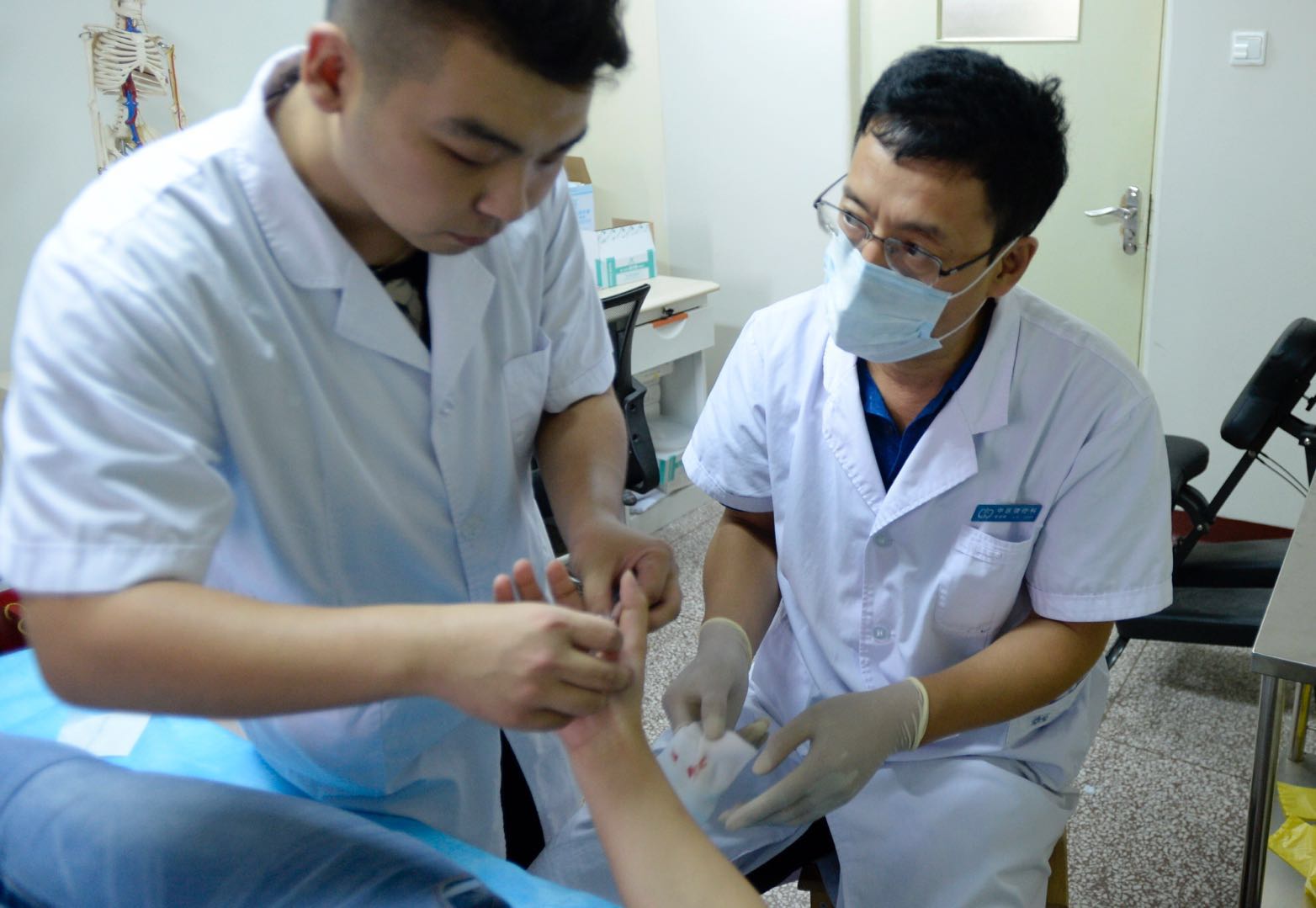 贺登峰（右）在指导学生进行针刀治疗。