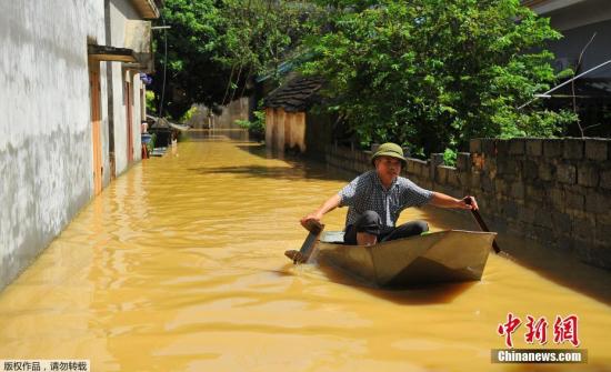 图为当地时间10月12日，越南宁平，当地民众划船出行。由于连日暴雨引发洪涝，街道已成汪洋。