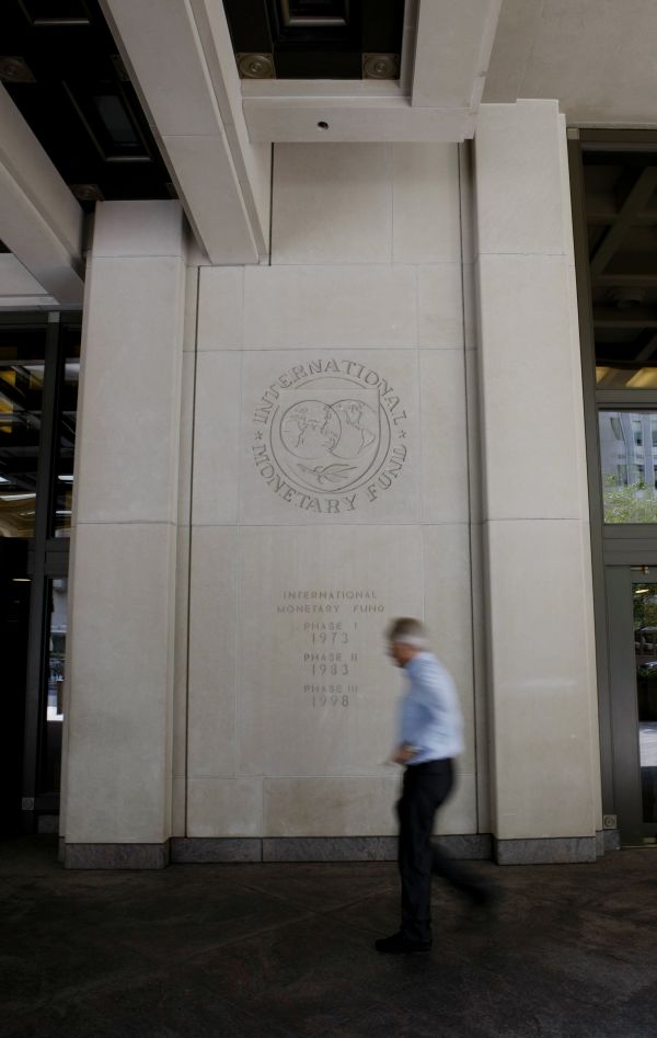  资料图片：在美国首都华盛顿，一名男子经过位于市区的国际货币基金组织大楼。 新华社记者 方喆 摄