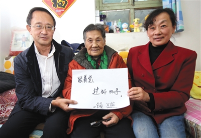 10月17日，89岁的刘智和女儿女婿一起展示家庭对十九大的寄语。新京报记者 王贵彬 摄