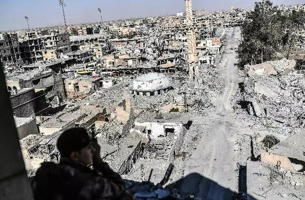 一名“叙利亚民主军”成员10月16日在拉卡一座建筑内监视周边区域。新华社/法新