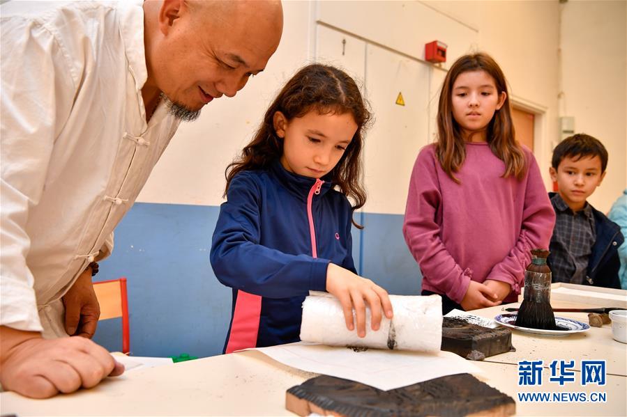 10月19日,在法国圣日耳曼昂莱的让·穆兰小学,学生在魏立中的指导下