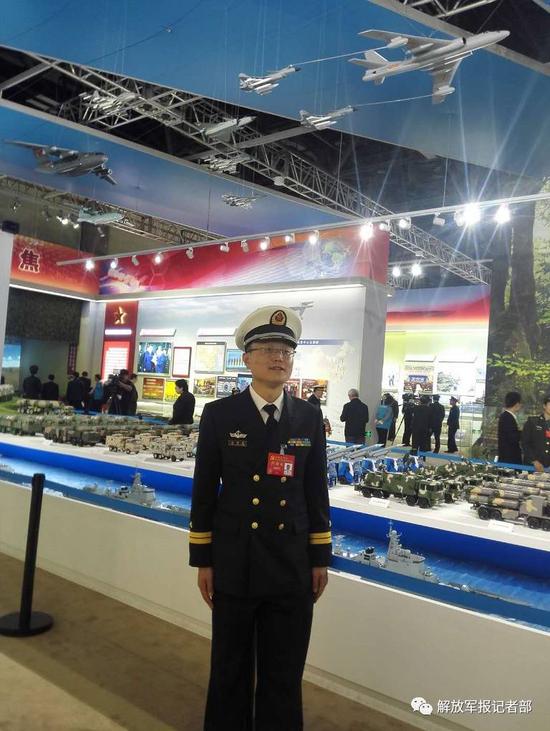 温国良与战车模型合影。记者 吴敏 摄