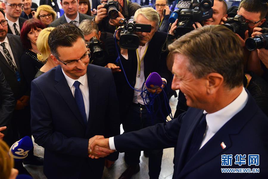 10月22日，在斯洛文尼亚首都卢布尔雅那，斯洛文尼亚现任总统帕霍尔（右）和卡姆尼克市长沙雷茨握手。