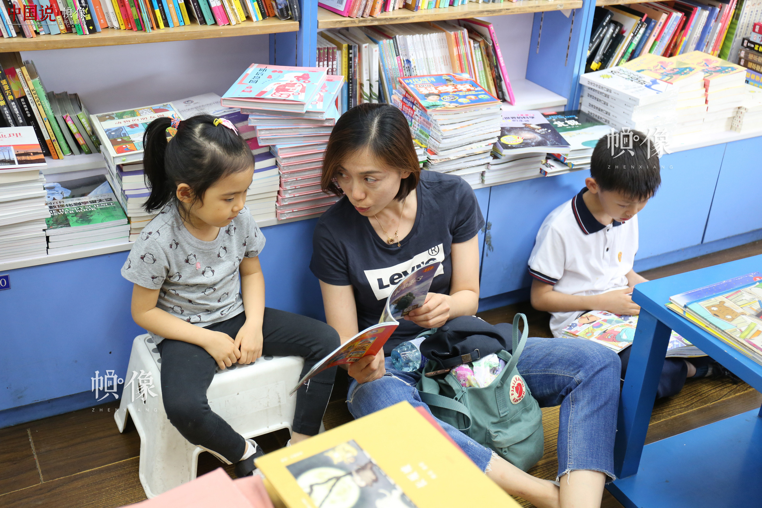 5月23日，北京三联书店美术馆店，一位妈妈给女儿读书。 中国网记者 赵超 摄