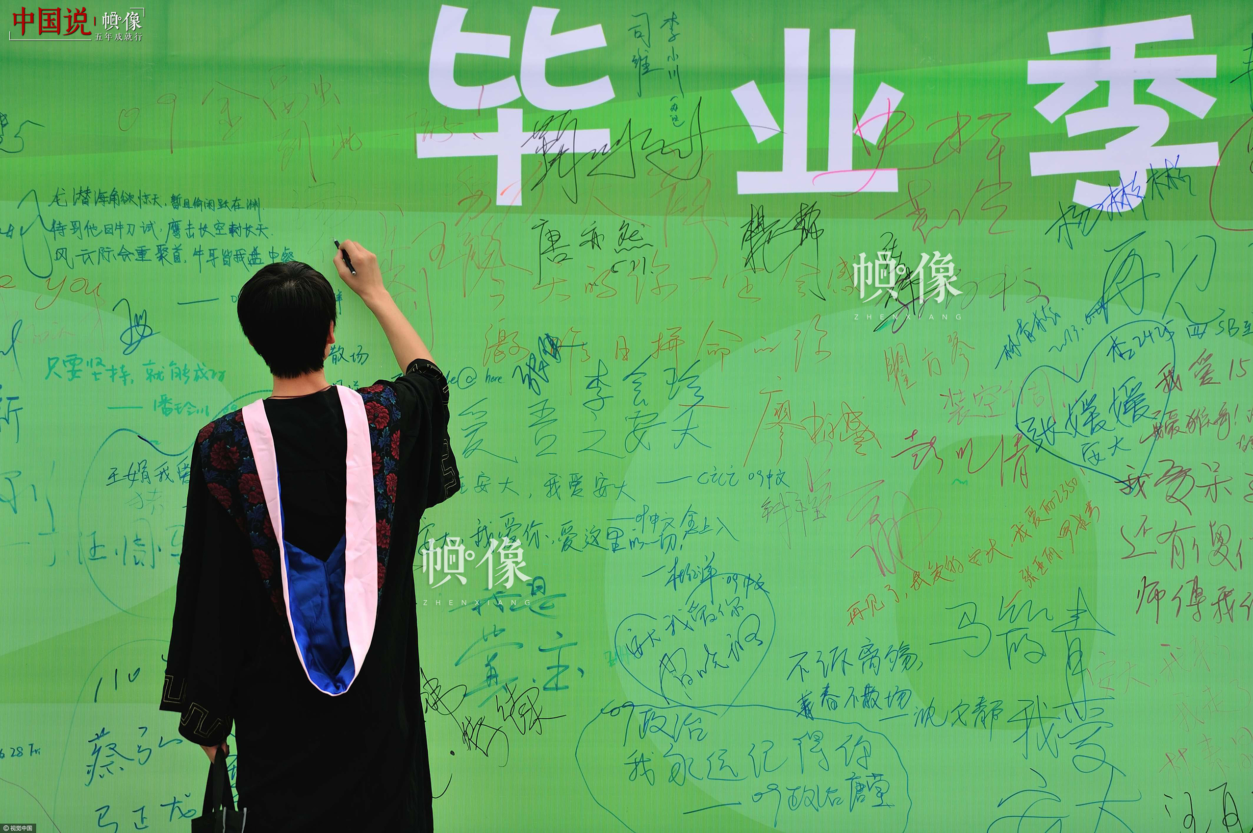 2013年6月28日，合肥，安徽大學，一位畢業生在畢業版上簽名。視覺中國供圖
