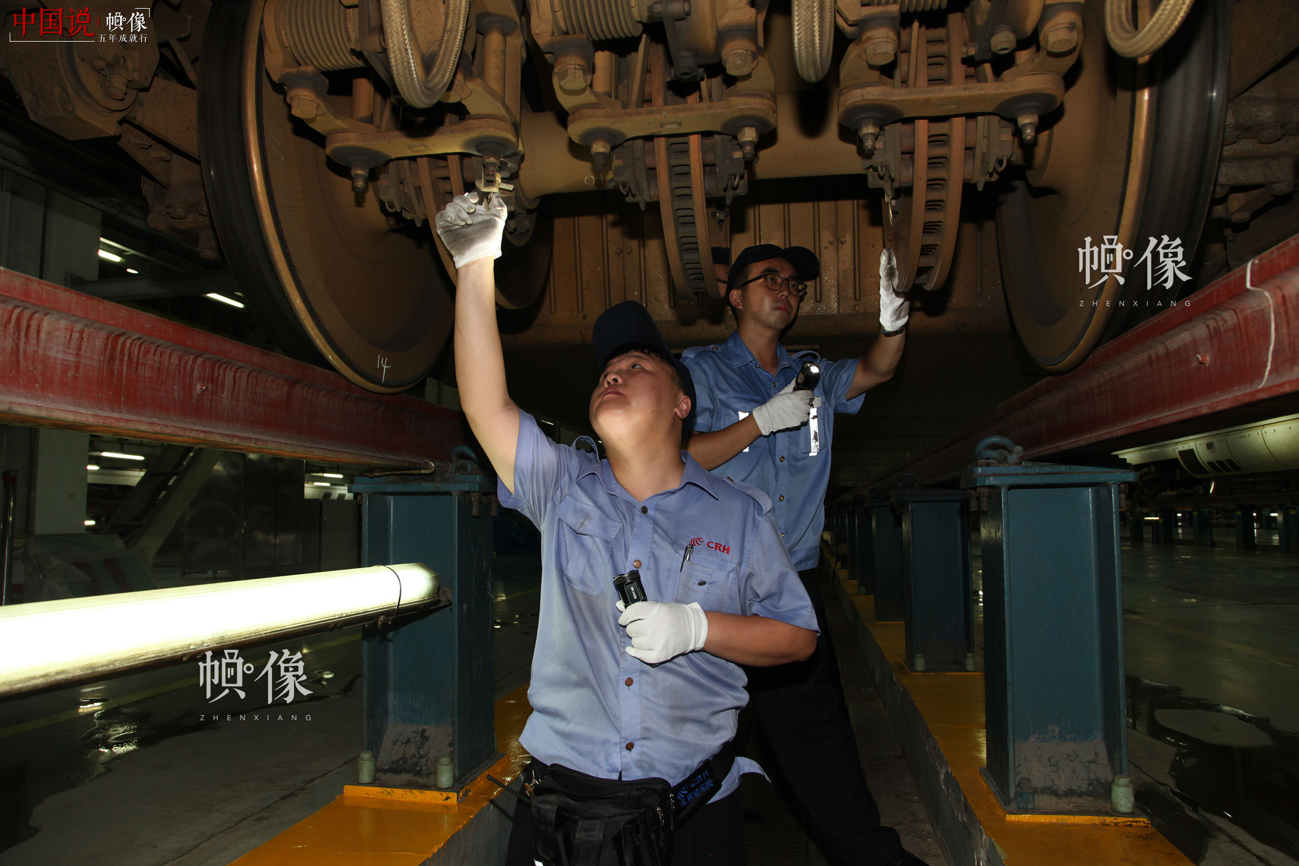 作业人员对车底转向架进行检修。北京动车段 李博 供图
