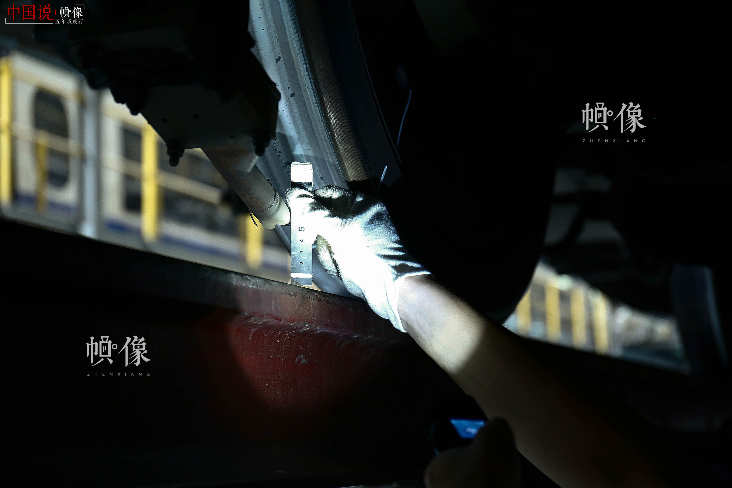 车辆行驶中需要利用撒砂系统增加轨面摩擦力，作业人员利用钢板尺测量撒砂管与轨道之间的高度。中国网记者 黄富友 摄