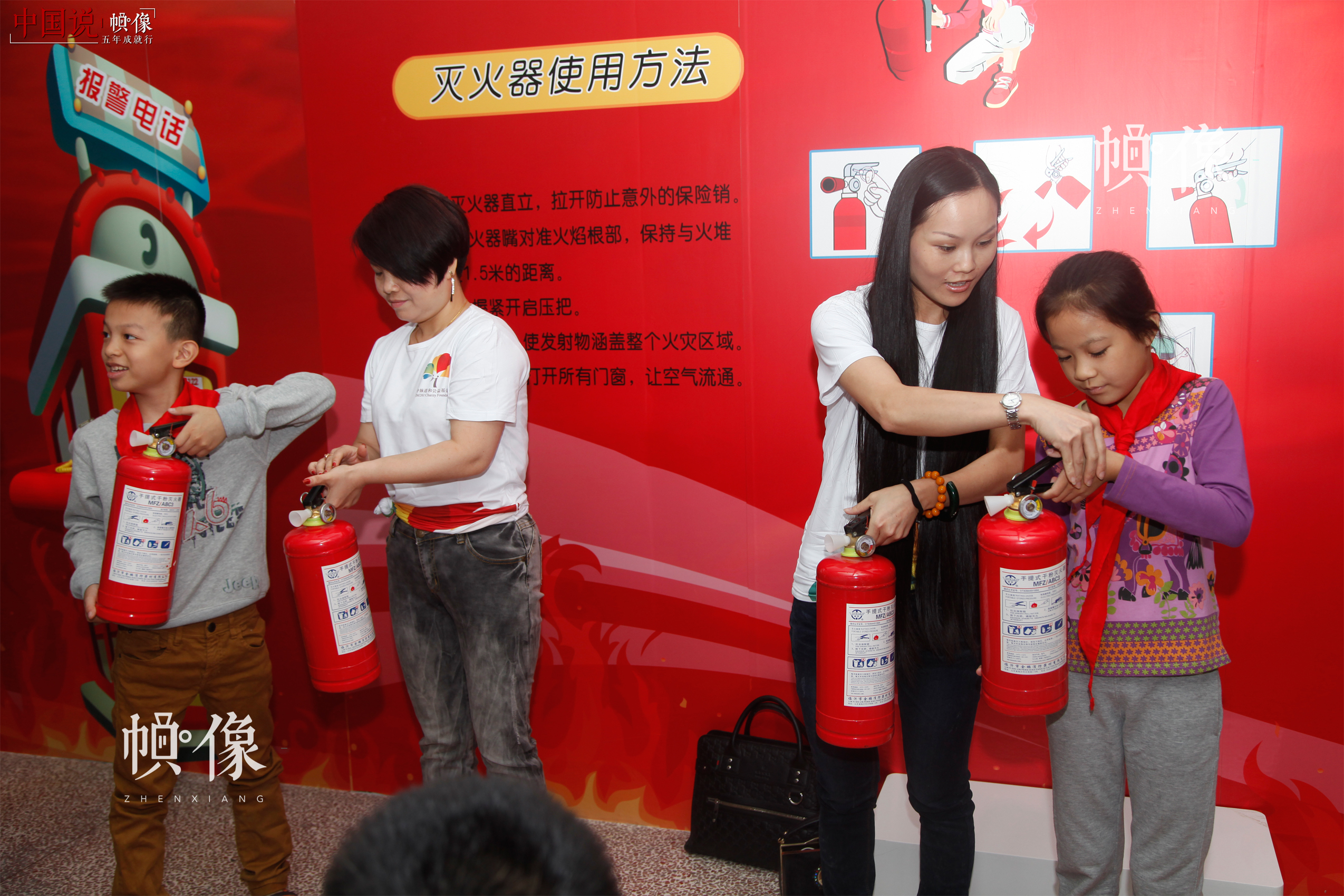 安全教育落地福建，志愿者与学生在安全体验教室进行灭火器使用的模拟演练。中国儿童少年基金会供图