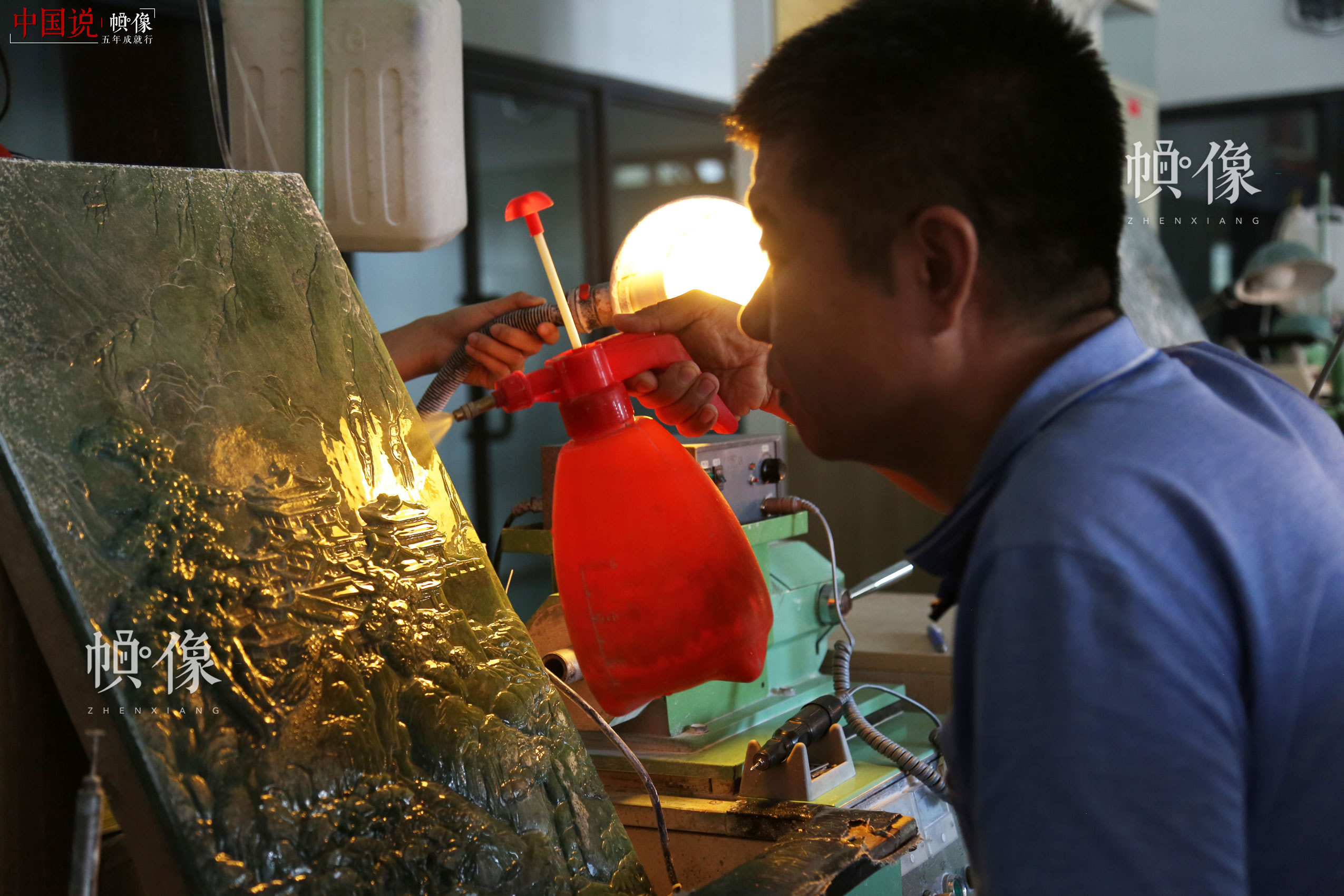 2017年9月5日，北京工美聚艺文化创意园区，中国玉雕大师张铁成用喷壶喷水去除玉雕画上的浮土。中国网记者 赵超 摄