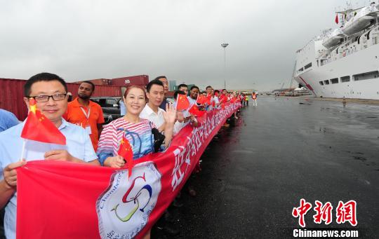 10月26日，安哥拉罗安达港码头，前来送行的中资企业员工挥动中国国旗，送别中国海军和平方舟医院船。江山 摄