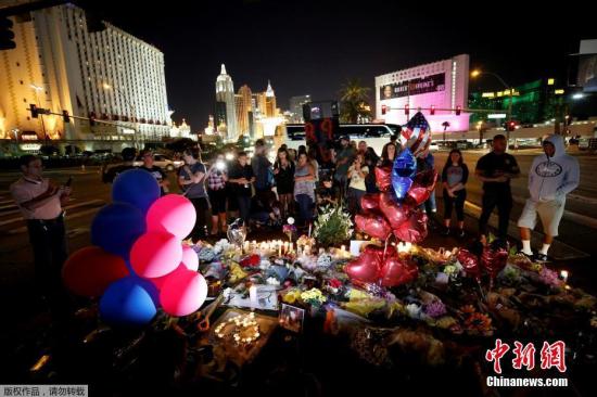 当地时间2017年10月4日,美国拉斯维加斯民众在事发现场附近悼念枪击案遇难者。