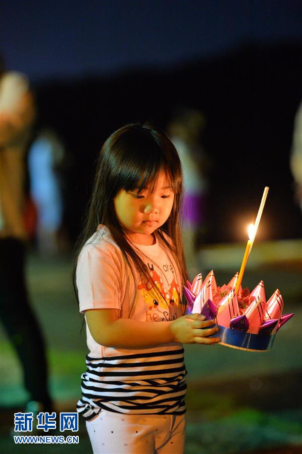 11月3日，在文莱斯里巴加湾市，一名儿童手捧水灯准备施放。