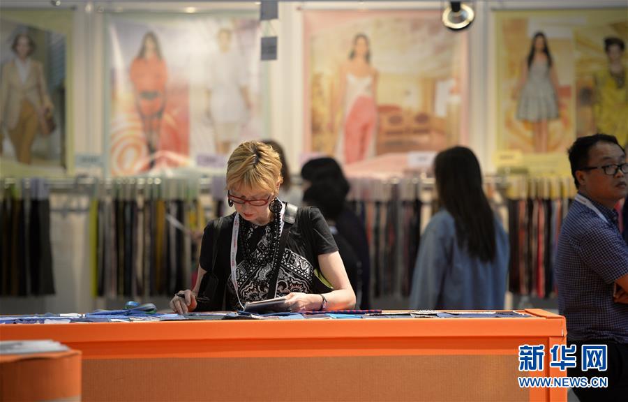 2015年7月21日，在美国纽约，观众在中国纺织品服装贸易展览会上了解中国纺织样品。 