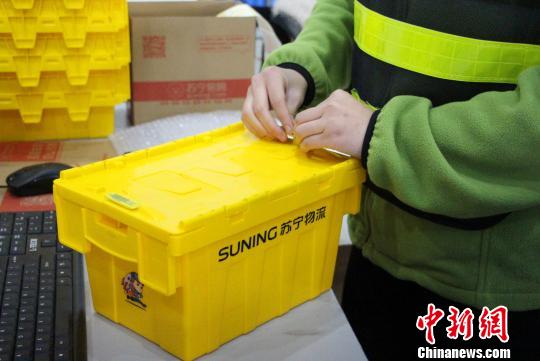 包装员正熟练地使用共享快递盒包裹商品. 赵晓 摄