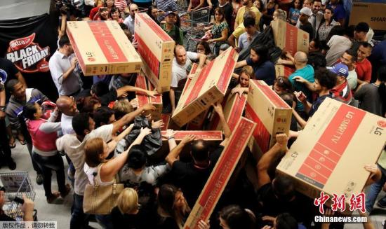 资料图：2016年11月25日，各国消费者迎来“黑色星期五”折扣日，民众倾巢出动来到大卖场，选购自己心水的货物。在众多商品中，大屏电视颇受青睐，几乎在每个卖场都能看到怀抱大电视的消费者。图为巴西圣保罗的一家商场里，大屏电视成为热门商品。