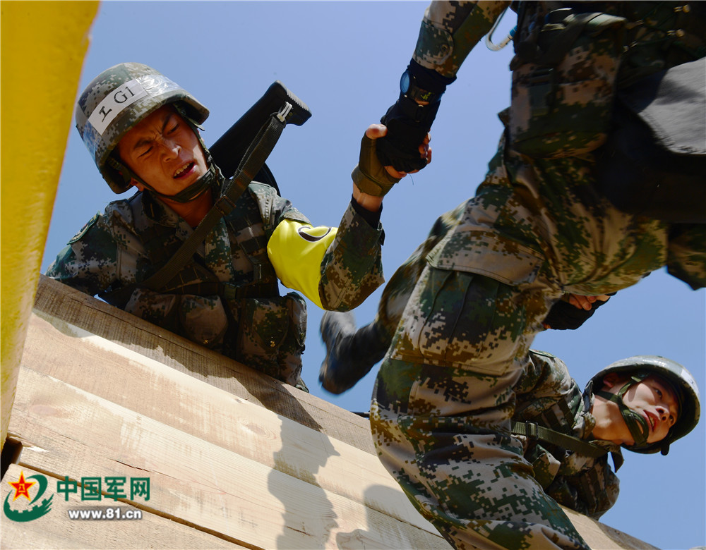 陆军工程大学野战工程学院参赛一队在对抗赛中协同翻越3米高墙障. .