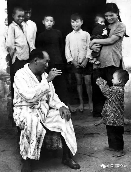 毛泽东畅游湘江后在农家门口与小孩逗趣，1958年 侯波 摄