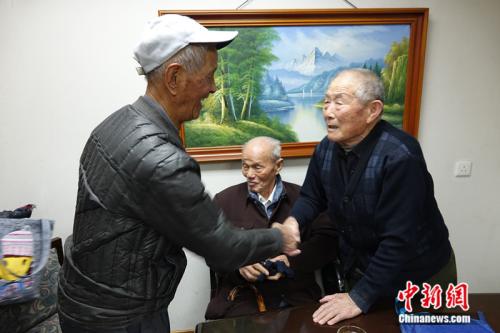 闫玉成（右）与同为被掳劳工的赵宗仁（左）、李良杰（中）见面。中新网记者 张尼 摄