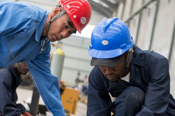 中国工人和肯尼亚工人在中航国际的内罗毕工厂一起组装卡车.