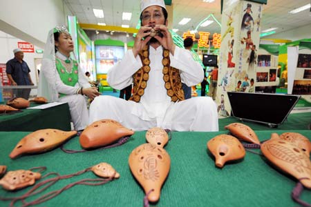 An artist of Hui ethnic group gives performance during the first Ningxia Culture Travel Products Show in Yinchuan, capital of northwest China's Ningxia Hui Autonomous Region, July 23, 2008.