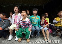 e 20 mai, les enfants des régions sinistrées reprennent les cours sous une tente. Une quarantaine d'écoliers du bourg de Tai'an de la ville de Dujiangyan y ont assistés. 