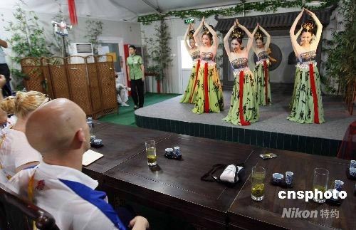 Dans une maison du thé du Village olympique, les athlètes anglais de l’équipe de plongeon se détendent en regardant un spectacle de danse traditionnelle chinoise.