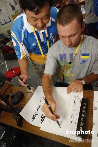 Le 29 juillet, Alexandre, athlète ukrainien de tir à l’arc, s’entraine à la calligraphie chinoise à l’aide d’un pinceau.