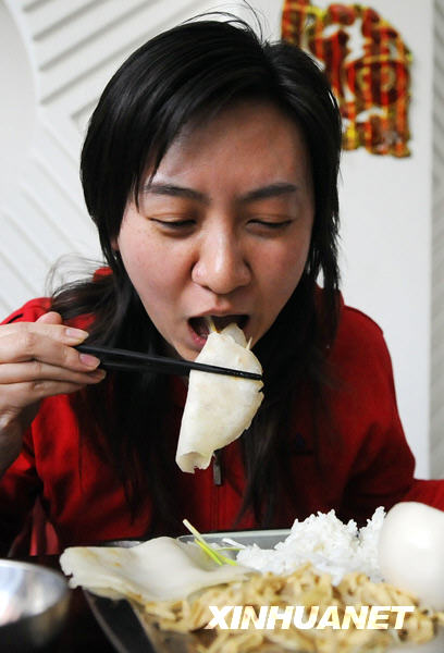 Le 4 février : une habitante de la ville de Changchun (nord-est de la Chine), en train de manger une galette de printemps.