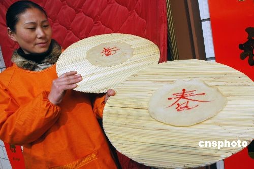 Le 4 février, une villageoise de la province du Henan montre au public ses galettes de printemps ornées du caractère chinois « Chun » (le printemps).