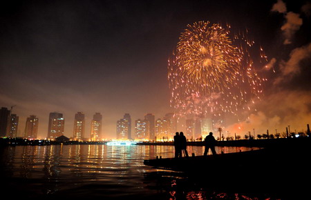 Le 9 février 2009, des gens en train de contempler les feux d&apos;artifice pour célébrer la fête des Lanternes à Zhengzhou, dans la province du Henan (centre de la Chine). 