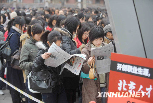 Le 4 mars, de nombreuses jeunes femmes diplômées demandeuses d'emploi en train de faire la queue devant les portes de la foire de l'emploi pour les diplômés de Beijing.