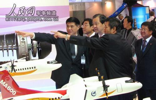 L'ambassadeur de Chine en France, Kong Quan (troisième à gauche), et le directeur adjoint de la Commission d'Etat pour le développement et la réforme, Zhang Xiaoqiang (premier à gauche), visitent le stand du Groupe de l'Aviation nationale de Chine.