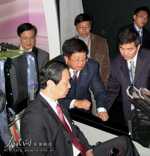 L'ambassadeur de Chine en France, Kong Quan, en train d'essayer le simulateur de l'avion-école supérieur L15, exposé par le Groupe de l'Aviation nationale de Chine.