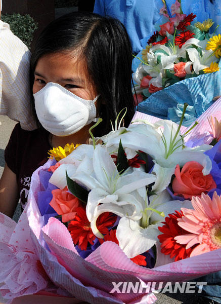 Fleurs à la main, la fillette, premier cas confirmé de la grippe A/H1N1 à Nanjing, est parfaitement guérie et s'apprête à sortir de l'hôpital. (Photo prise le 23 juin)