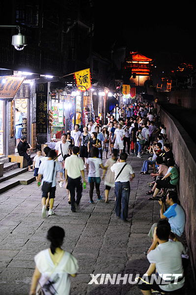 Vue nocturne de la rivière Tuojiang dans la ville de Fenghuang, photo prise le 7 juillet